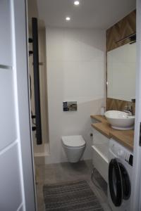 a bathroom with a white toilet and a sink at Apartament Skipper in Gdańsk