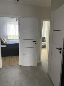 1 dormitorio con una puerta que conduce a una cama en Apartament Skipper en Gdansk