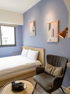 a bedroom with a bed and a chair and a table at Febe旅日子 in Taichung