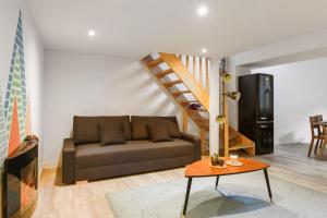 a living room with a couch and a staircase at Large and calm flat in the heart of Lille - Welkeys in Lille