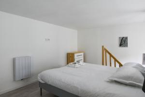 - une chambre blanche avec un lit et un radiateur dans l'établissement Grand T1bis au calme proche République en plein coeur de Lille - Welkeys, à Lille