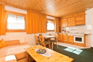 a kitchen and living room with a couch and a table at Appartement Lärchenhof in Samnaun