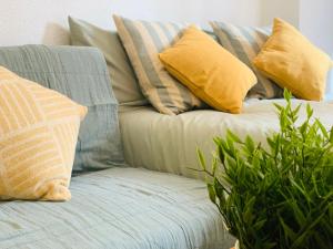a green couch with pillows and plants on it at ACUARIO 22 in Benalmádena