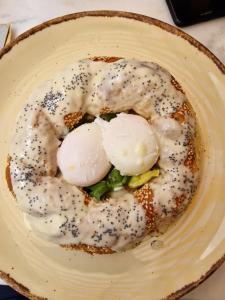 un plato de comida con dos huevos escalfados. en Concierge Monastiraki en Atenas