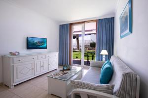 uma sala de estar com um sofá e uma mesa em Jacarandas Beach em Playa del Inglés