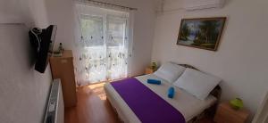 sypialnia z łóżkiem z fioletowo-białym kocem w obiekcie Major apartman w mieście Kehidakustány