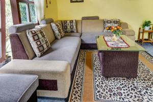 ein Wohnzimmer mit einem Sofa und einem Tisch in der Unterkunft OYO Homes 90984 Kampung Wisata Ekologi Puspa Jagad in Blitar