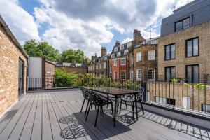 patio ze stołem i krzesłami na balkonie w obiekcie Be London - The Bloomsbury Residences w Londynie