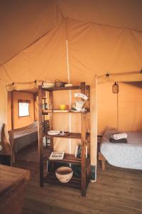 a room with two bunk beds in a tent at Le Noyer in Rougnat