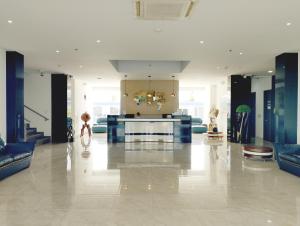 een grote kamer met een lobby met blauwe meubels bij Hotel Royal Elim International in Cali