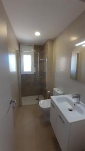 a bathroom with a toilet and a sink and a shower at Apartamentos Dins Mar Apto. 2 in Torredembarra