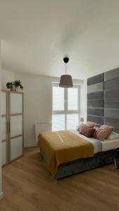 a bedroom with a large bed and a large window at Apartament Barlickiego in Bielsko-Biała