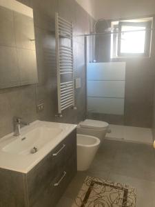 La salle de bains est pourvue d'un lavabo blanc et de toilettes. dans l'établissement Dimora AnVi, à Bari