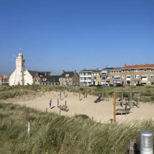 een strand met een groep mensen die in het zand spelen bij Shoreline Apartment Katwijk in Katwijk aan Zee