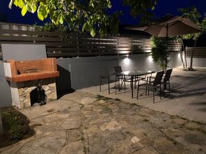 a patio with a table and chairs and an umbrella at V-Suites 2 in Potos
