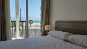 a bedroom with a bed and a view of the beach at Apartamentos Dins Mar Apto. 2 in Torredembarra