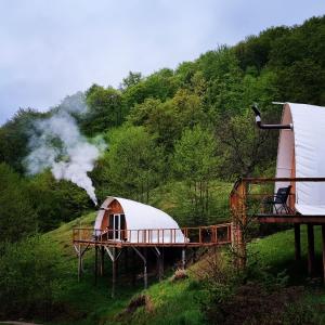 a yurt with smoke coming out of it in a field at Sunrise Glamping Retreat in Galeşu