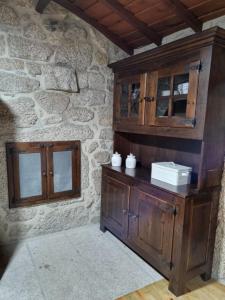 una camera con un armadio in legno e un muro in pietra di Casa da Mimi a Soajo Altre 13 foto
