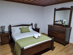 una camera da letto con un letto con un comò e uno specchio di Casa da Mimi a Soajo