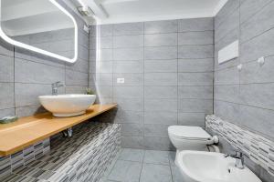 une salle de bain avec un lavabo, des toilettes et un miroir dans l'établissement Appartamento Cesare, à Sirmione 11 autres photos