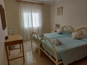 a bedroom with two beds and a table and a window at Apartamento Sunny Velamar in Patroves +14 photos