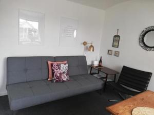 a living room with a gray couch and a table at Motel Hune Apartments in Blokhus