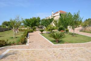 a walkway in a park with trees and a building at Paloma in Karavádhos