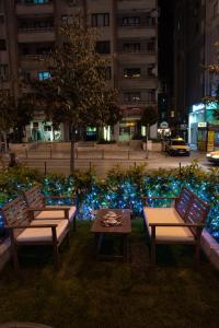 un parque con bancos, una mesa y luces azules en Piskin Hotel en Denizli
