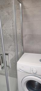 a washing machine in a bathroom with a shower at Apartamento con vistas al puerto deportivo Las Fuentes in Alcossebre