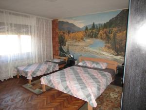 um quarto com duas camas e uma pintura de um rio em Apartman Milena em Kladovo