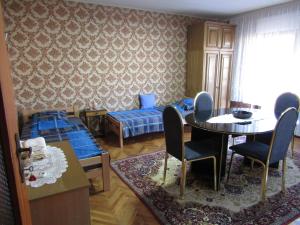 um quarto com duas camas e uma mesa e cadeiras em Apartman Milena em Kladovo