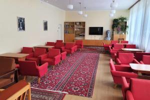 a room with red chairs and tables and a tv at Turisticky Raj in Hrabušice