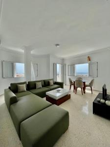 a living room with a green couch and a table at Soltane Résidence in Hammamet