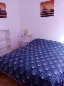 - un lit bleu dans une chambre avec une couette bleue dans l'établissement Chez charline, à Sainte-Mère-Église