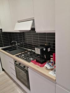 um balcão de cozinha com um fogão e um lavatório em Appartamento Valentina em San Vincenzo