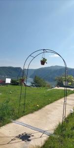 a metal arch with a basket on it next to a sidewalk at Casa De Vacanță Maga Dubova in Dubova