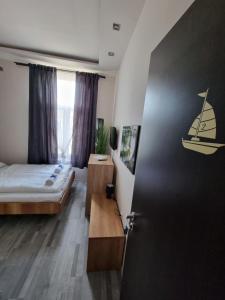 1 dormitorio con cama, escritorio y puerta en Sleeping Sailor Boutique Hotel, en Siófok