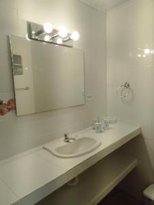 uma casa de banho branca com um lavatório e um espelho em ScubaPortobelo em Portobelo