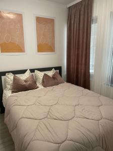 een slaapkamer met een groot wit bed met kussens bij Apartman Carpe Diem in Jajce