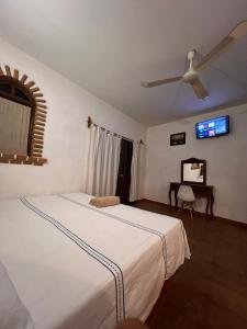 a bedroom with two beds and a table and a ceiling fan at Casa Terranova in Puerto Escondido +40 photos