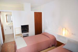 a small bedroom with two beds and a fireplace at Cozy Townhouse in the heart of Cadaqués by by JA Coderch in Cadaqués
