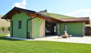 een kas met een terras en een gazon bij Il casotto nelle Langhe in Farigliano