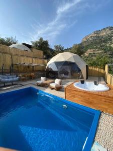a blue swimming pool with a tent in a yard at Kabak Freedom Deluxe Hotel in Faralya