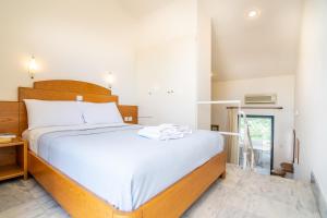a bedroom with a large bed with white sheets at Orestis Hotel Sea View Apartments in Stalos
