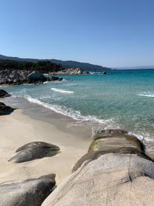 a beach with some rocks and the ocean at petros house in Sarti