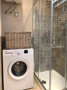 a washing machine in a bathroom with a shower at Alghero casa con piscina lido fronte mare in Alghero