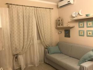 a living room with a couch and a window at Alghero casa con piscina lido fronte mare in Alghero
