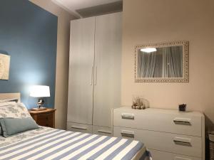 a bedroom with a white cabinet and a bed at Alghero casa con piscina lido fronte mare in Alghero