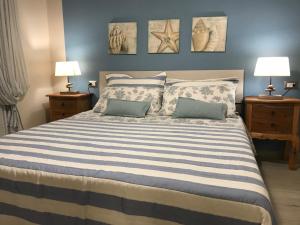 a bedroom with a large bed with two lamps at Alghero casa con piscina lido fronte mare in Alghero +7 photos