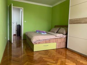 1 dormitorio con 1 cama en una habitación con paredes verdes en Apartman Ruby, en Doboj